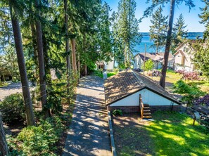 A residential area with a clear view of a lake, surrounded by tall trees and houses.