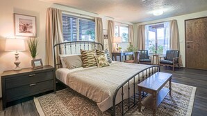 A bedroom with a bed, bedside tables, a desk, and chairs. - Fairyland Cottage: Waterfront+Hot Tub+Beach+Clam (Poulsbo)
