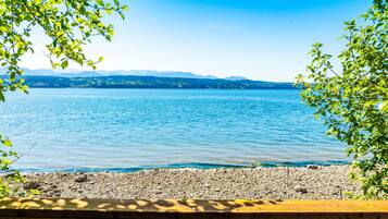 Une vue sur le lac, avec un banc en bois au premier plan et un ciel dégagé.