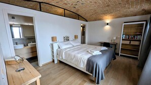 Ein Schlafzimmer mit einem Bett, einem Nachttisch, einer Lampe und einem Bücherregal.