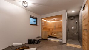 Un moderno spa con mesas de masaje, sauna y zona de ducha.