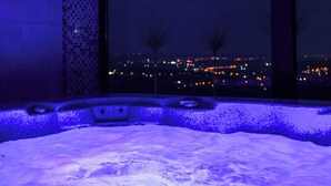 A hot tub with a view of a cityscape at night. - Alexander Resort (Belgrade)