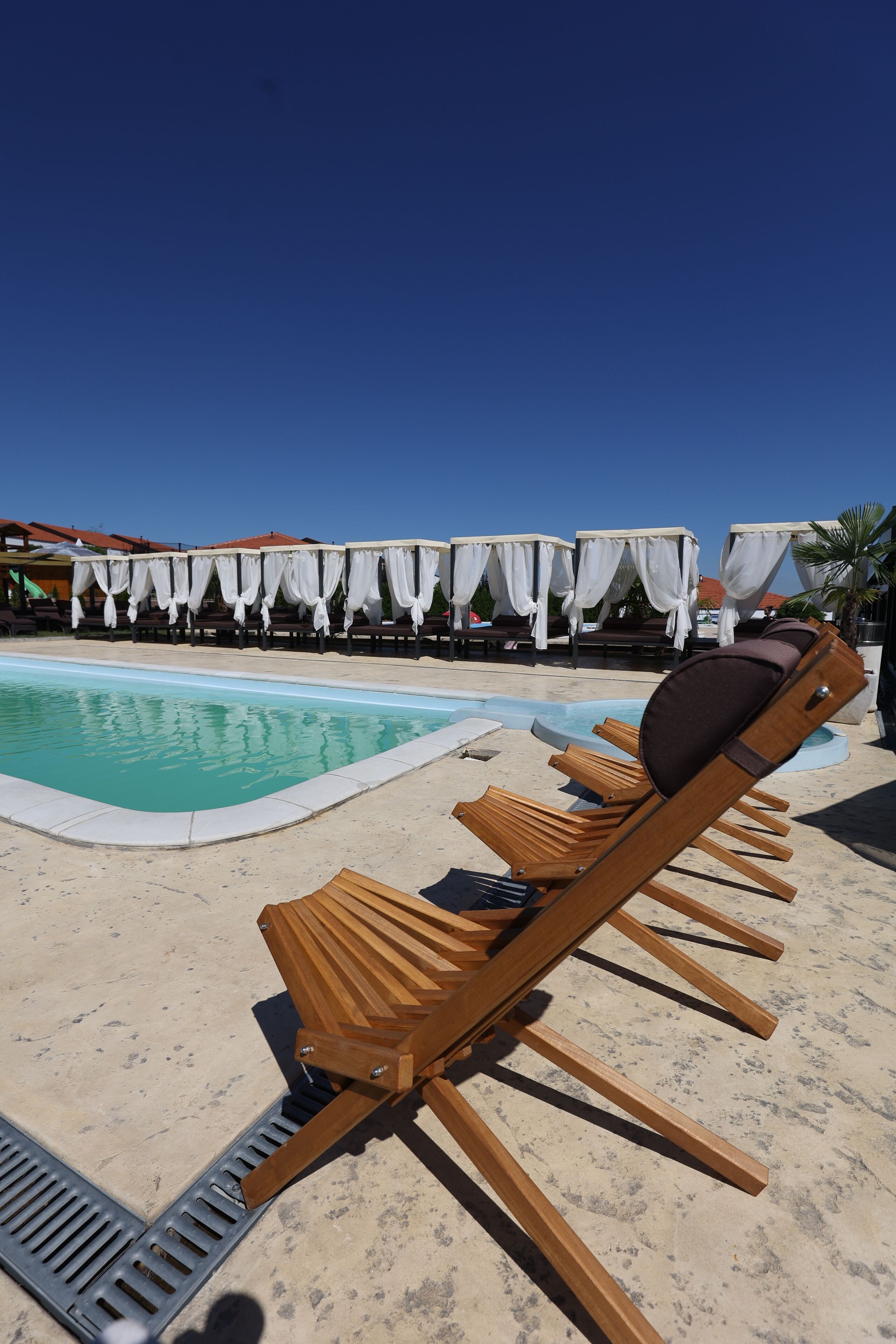 A poolside area with lounge chairs and covered seating.