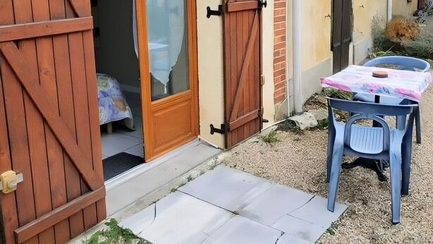A rustic building with a wooden door and a welcome sign.