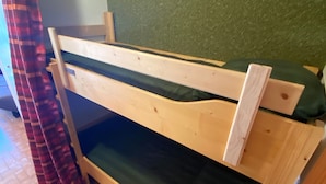 Un lit superposé avec un matelas vert et une structure en bois.