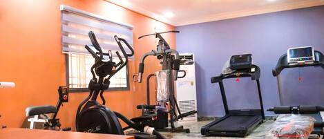 A gym with cardio equipment, a treadmill, and a stationary bike.
