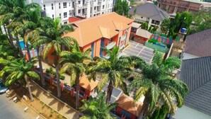 A multi-story building with a flat roof, surrounded by palm trees. - Madaki's Executive Suites (Abuja)