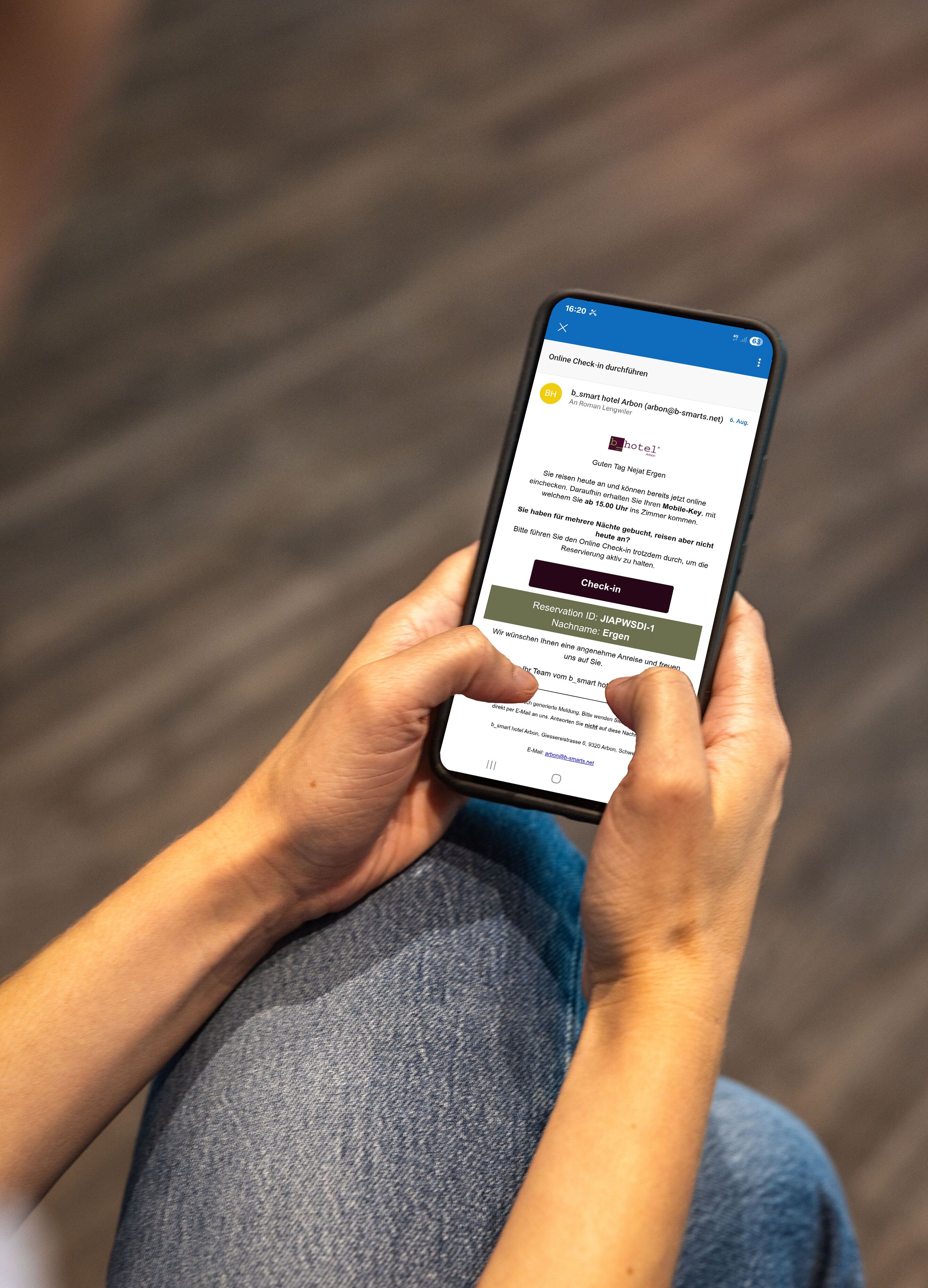 Eine Person hält ein Smartphone mit einer Hotelsuchseite.