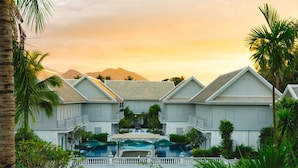 Un resort con varias construcciones, una zona de piscina y vistas a las montañas.