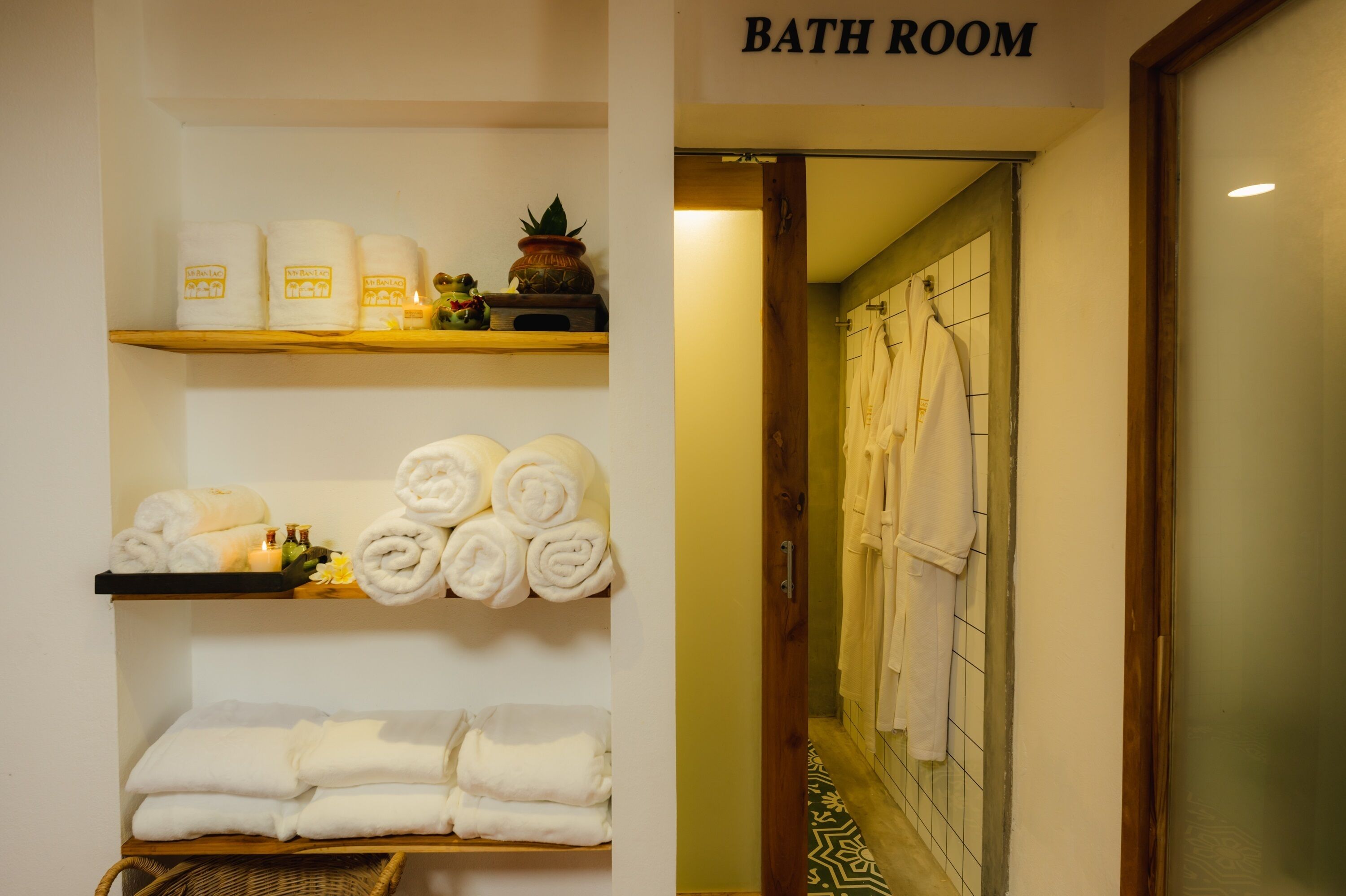 Ein Badezimmer mit Regalen, auf denen Handtücher liegen, und einem Schild, das den Raum kennzeichnet.