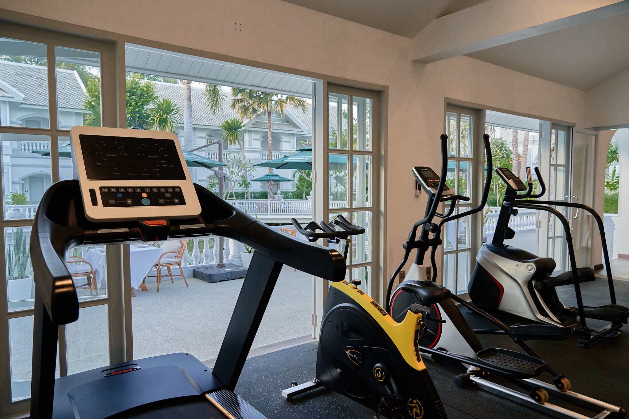 Una palestra con tapis roulant, ellittiche e un computer portatile su un tapis roulant.