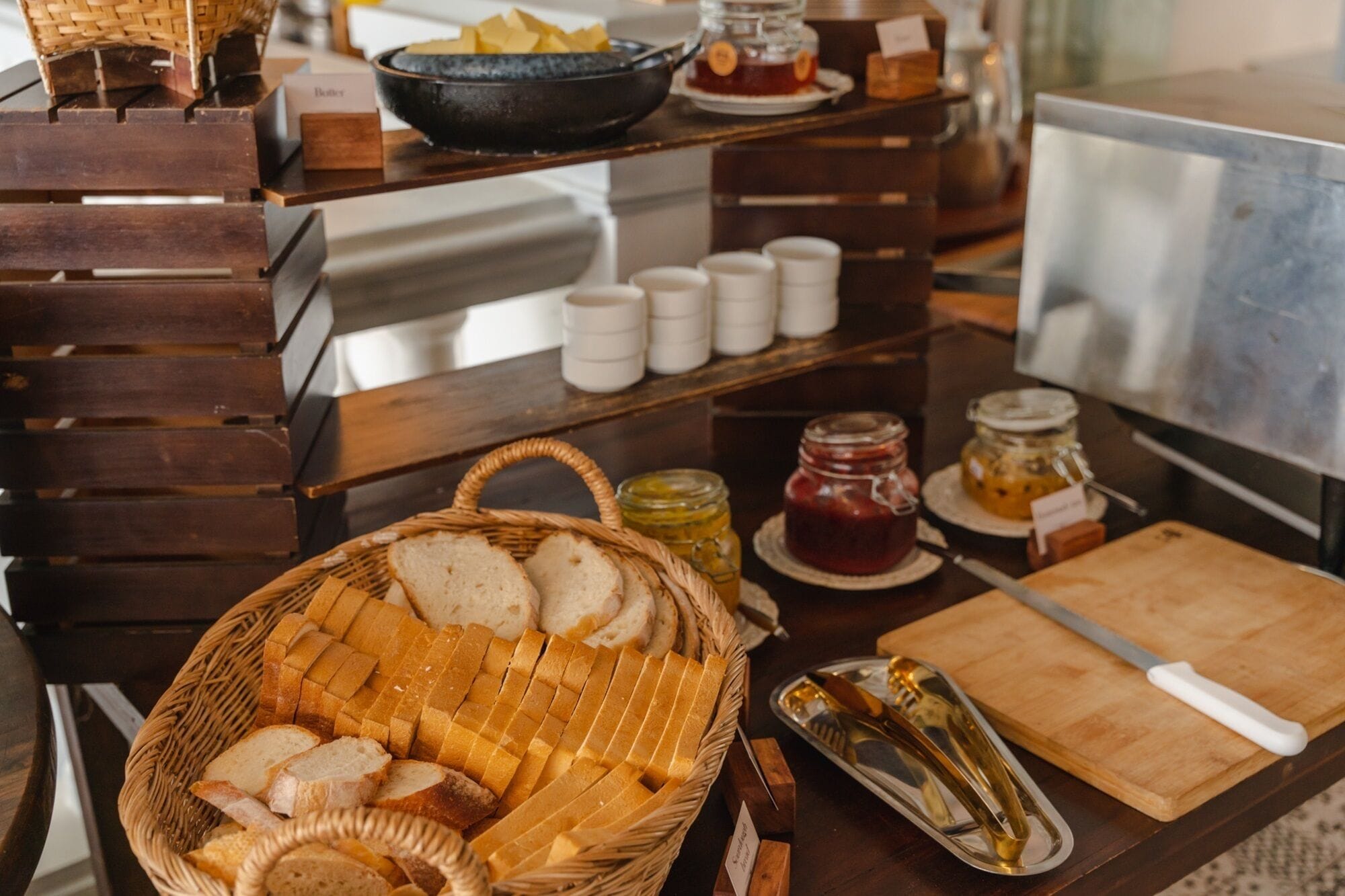 Una mesa de buffet con pan, mermeladas y salsas.