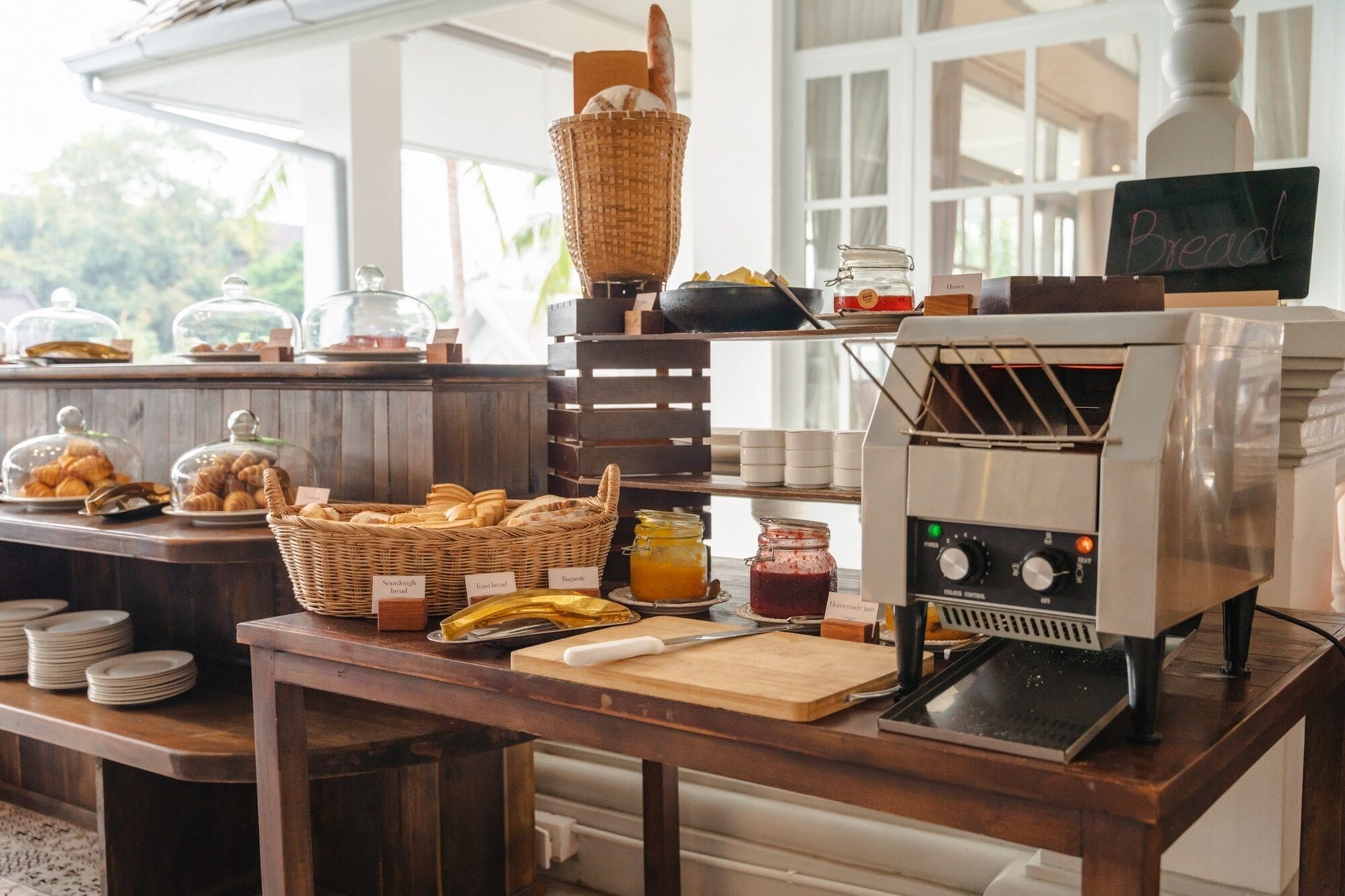 A breakfast buffet with bread, pastries, and jams.