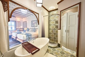 Een aparte badkuip en douche, een bubbelbad, een regendouche