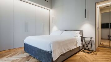 Una camera da letto moderna con un letto grande, un armadio a muro e un comodino.