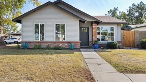 A single-story house with a front porch, a garage, and a well-maintained lawn. - Cottage Evergreen: Outdoor Grille, Patio w/ Putt! (Mesa)