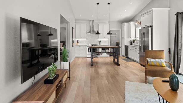 A modern kitchen with white cabinets, a stainless steel refrigerator, and a central island. - Cottage Evergreen: Outdoor Grille, Patio w/ Putt! (Mesa)