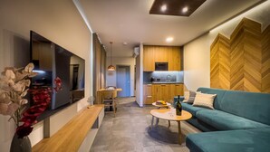 A modern living room with a sofa, a coffee table, and a TV on the wall. - APLEND Lake Resort  (Štrba)