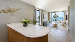 A modern living room with a marble countertop, a sofa, a coffee table, and a view of the sea. - voco Monaco Dubai Heart of Europe by IHG (Dubai)