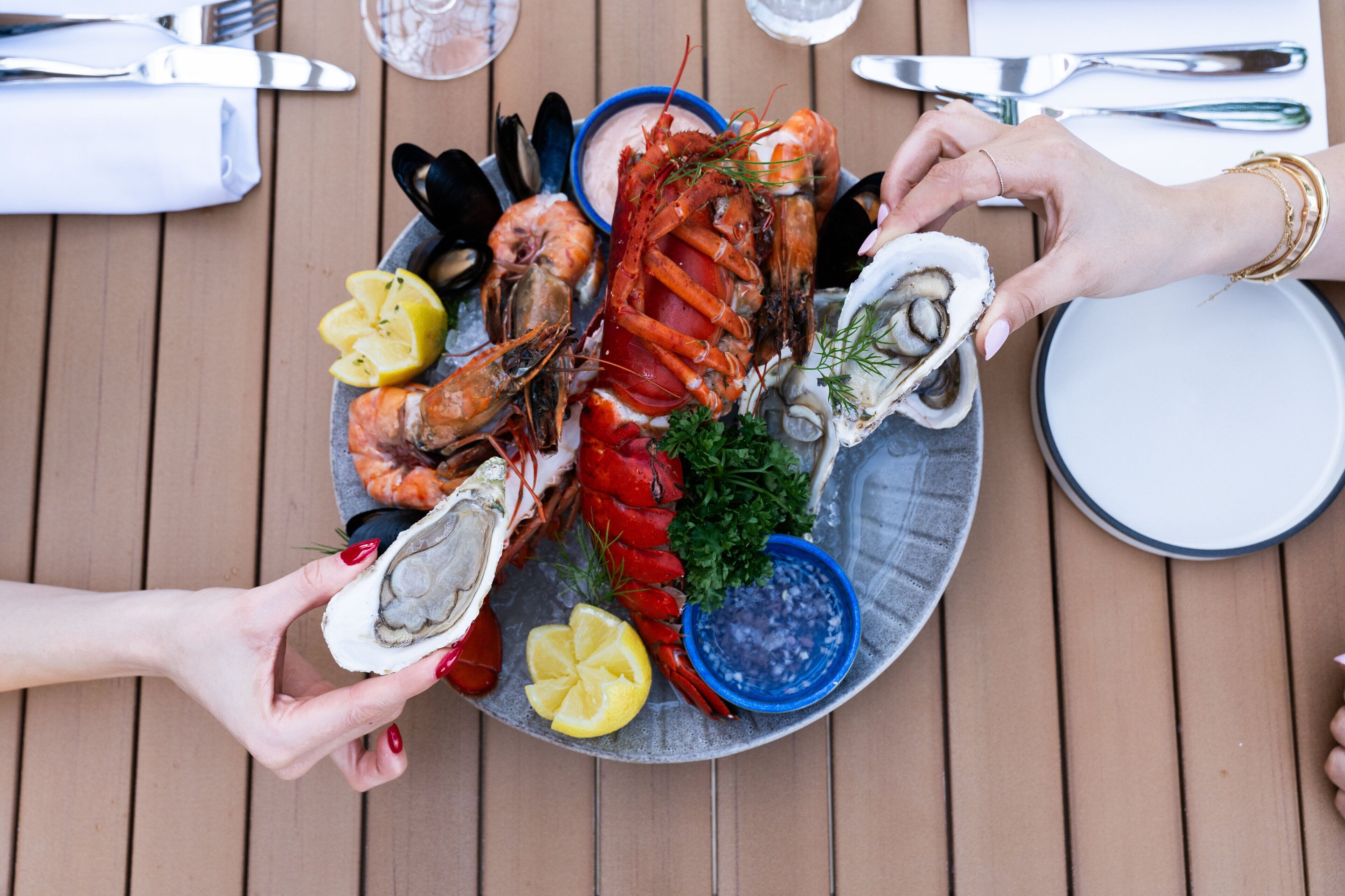A seafood platter with various shellfish and garnishes on a plate.