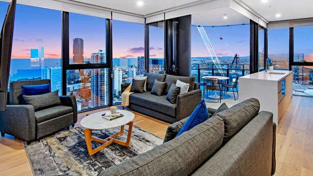 Amplia sala de estar con vistas a la ciudad, un balcón con comedor y una cocina moderna.