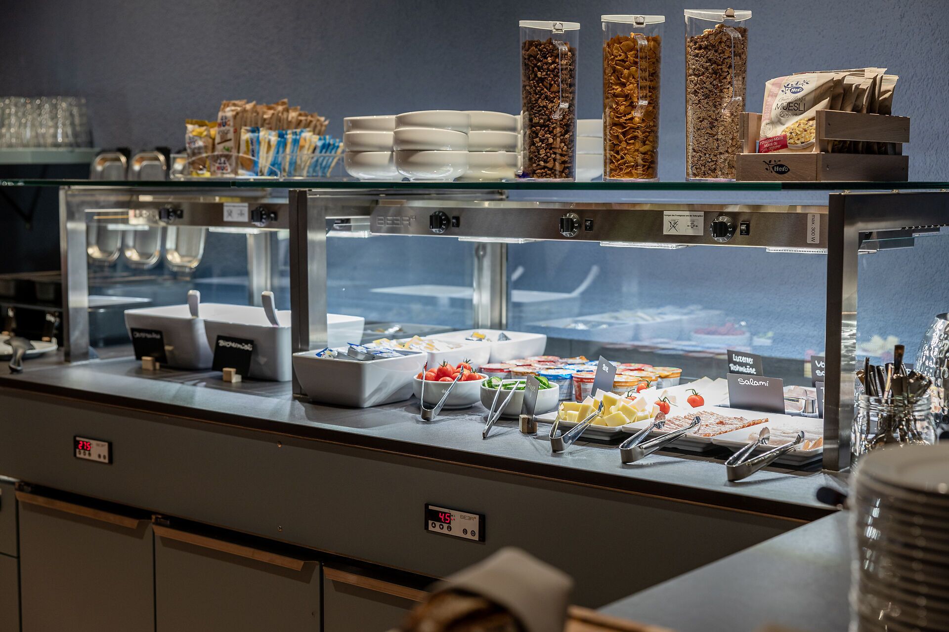 Un buffet proposant une variété de plats et de récipients, notamment des bols, des plateaux et une machine à café.