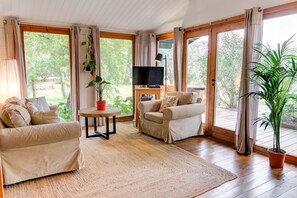 Un salon spacieux avec deux canapés, un téléviseur et une plante en pot.