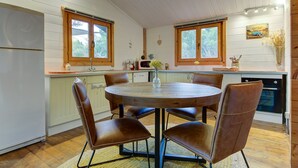 Une cuisine avec une table ronde en bois, des chaises en cuir marron et des armoires en bois.