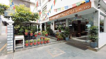 A hotel entrance with a sign indicating breakfast, lunch, and dinner services.