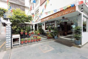 A hotel entrance with a sign indicating breakfast, lunch, and dinner services.