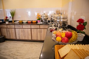 A kitchen with a marble countertop, a fruit bowl, and various food items. - Magnificent Hotel (Kathmandu)