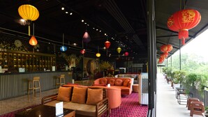 A modern interior with a bar area, seating with orange cushions, and red lanterns. - Family 64 Home (Van Ho)
