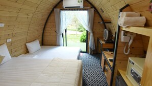 A cozy, single-room cabin with a bed, a small desk, and a telephone. - Family 64 Home (Van Ho)
