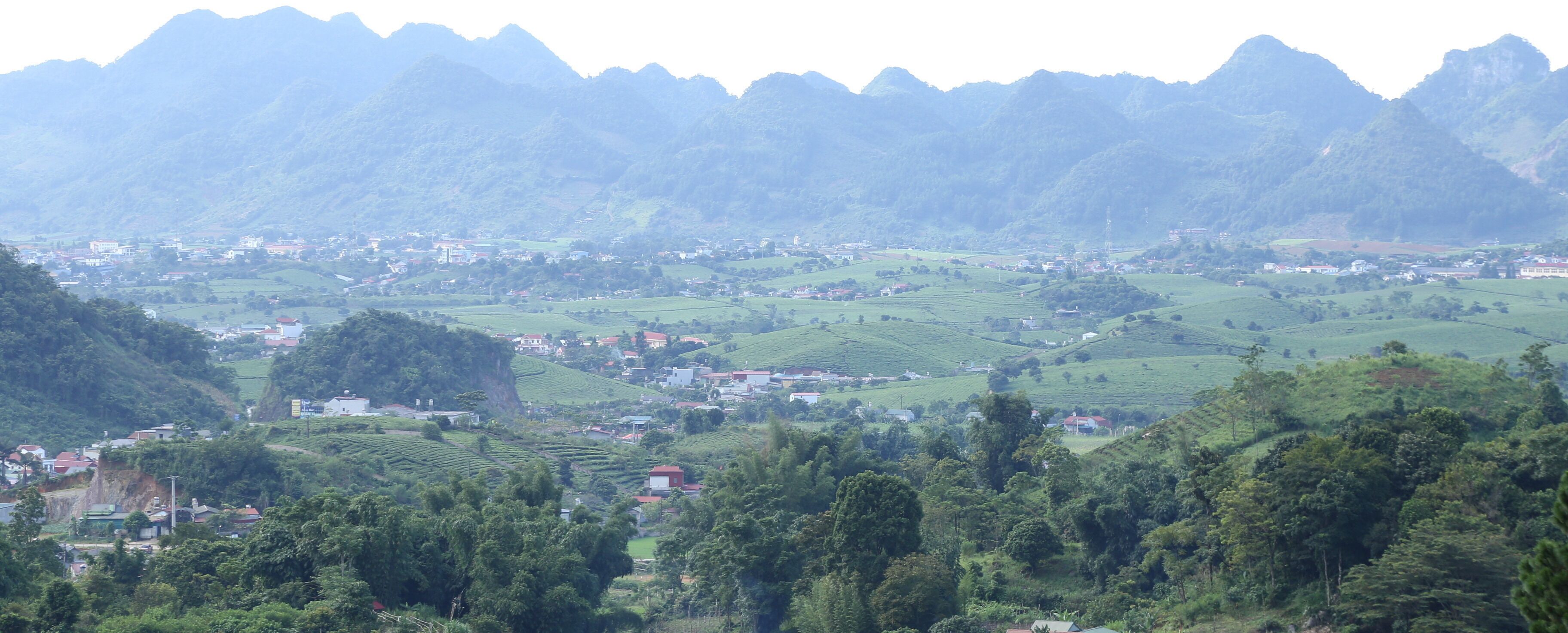 A mountainous landscape with terraced fields and scattered buildings.
