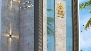Un moderno edificio de hotel con un letrero destacado que dice "HOTEL MIDTOWN".