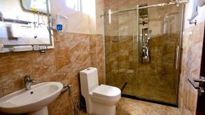 A bathroom with a sink, toilet, and glass-enclosed shower.