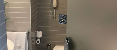 A compact bathroom with a toilet, a bidet, a towel rack, and a phone.