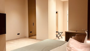 Una habitación de hotel moderna con una cama grande, un escritorio y un espejo.