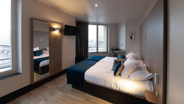 A modern hotel room with a large bed, a desk, and a TV. - HNG Hotel Nancy Gare (Nancy)