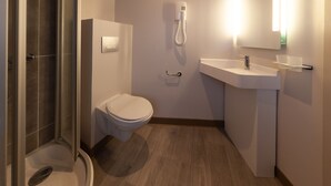 A modern bathroom with a shower, toilet, and sink. - HNG Hotel Nancy Gare (Nancy)