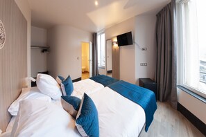 A hotel room with a large bed, a flat-screen TV mounted on the wall, and a window with curtains. - HNG Hotel Nancy Gare (Nancy)