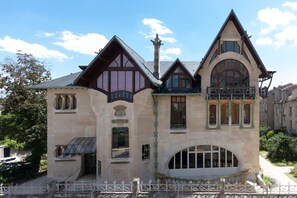 A large, historic building with a prominent tower, multiple windows, and a balcony. - HNG Hotel Nancy Gare (Nancy)