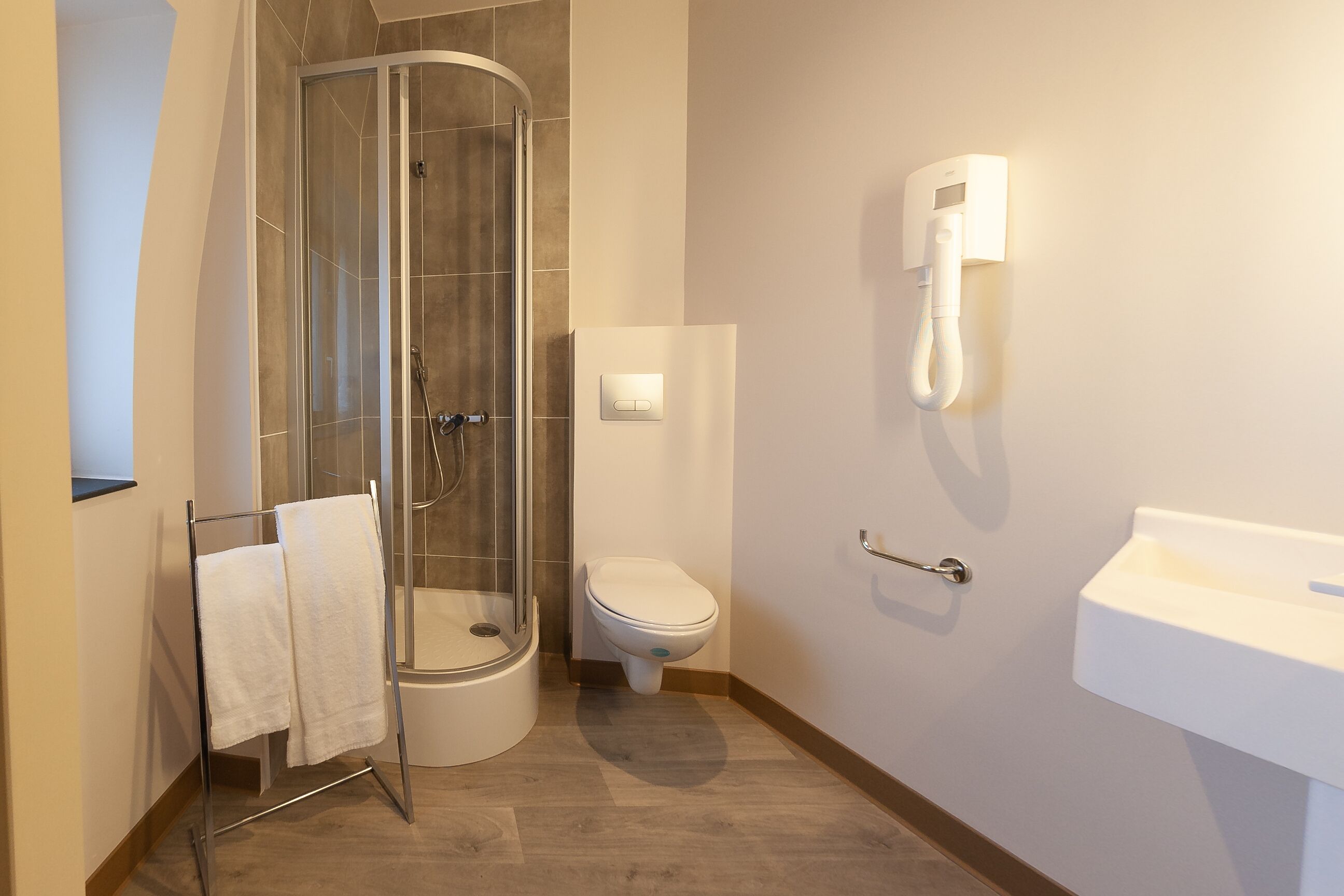 Comfort tweepersoonskamer | Badkamer | Een douche, een haardroger, handdoeken, zeep