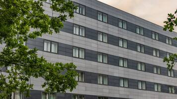 A multi-story building with a modern architectural design, featuring a grid of windows and a flat facade.