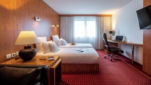 A hotel room with two beds, a desk, a chair, a TV, and a lamp. - CERISE Bordeaux Mérignac Aéroport (Merignac)