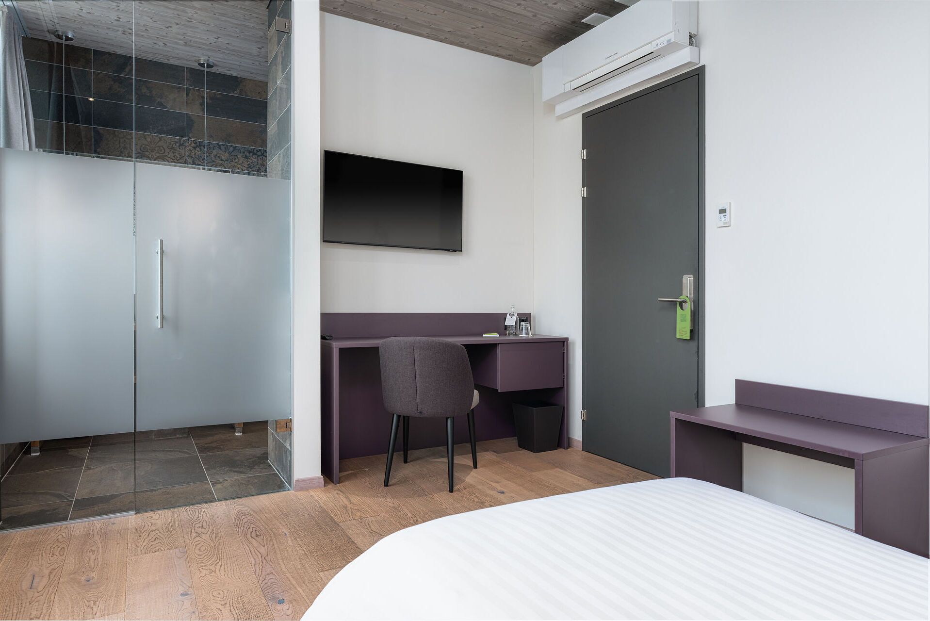 Ein modernes Schlafzimmer mit Bett, Schreibtisch, Stuhl und Kleiderschrank.