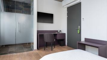 Ein modernes Schlafzimmer mit Bett, Schreibtisch, Stuhl und Kleiderschrank.