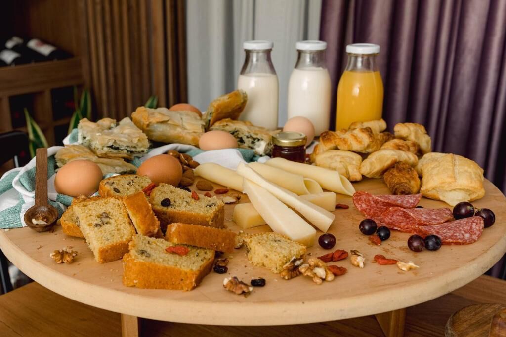 A breakfast platter with various foods and drinks on a wooden table.