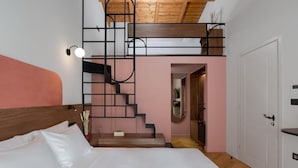 Une chambre à coucher avec un lit, un escalier et une porte.