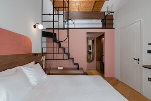 Un dormitorio con cama, escalera y puerta.